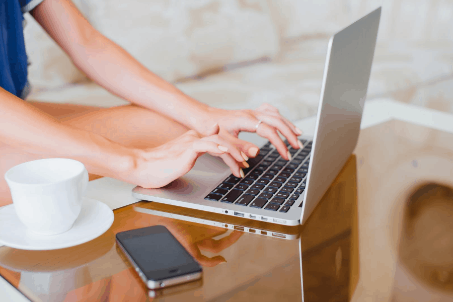 mujer escribiendo en una computadora portátil