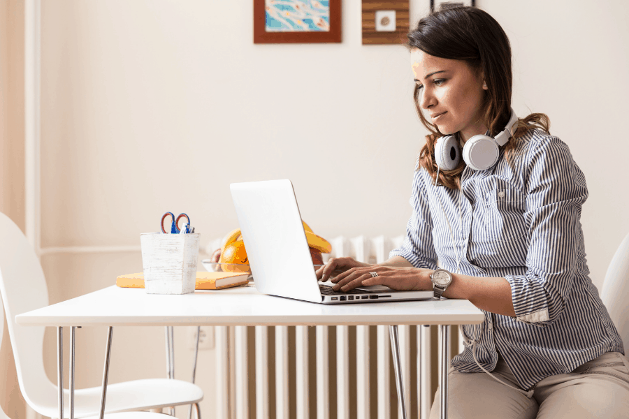 woman typing on a laptop at the kitchen table