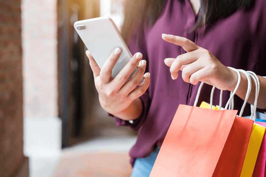 woman shopping and looking at a cellphone