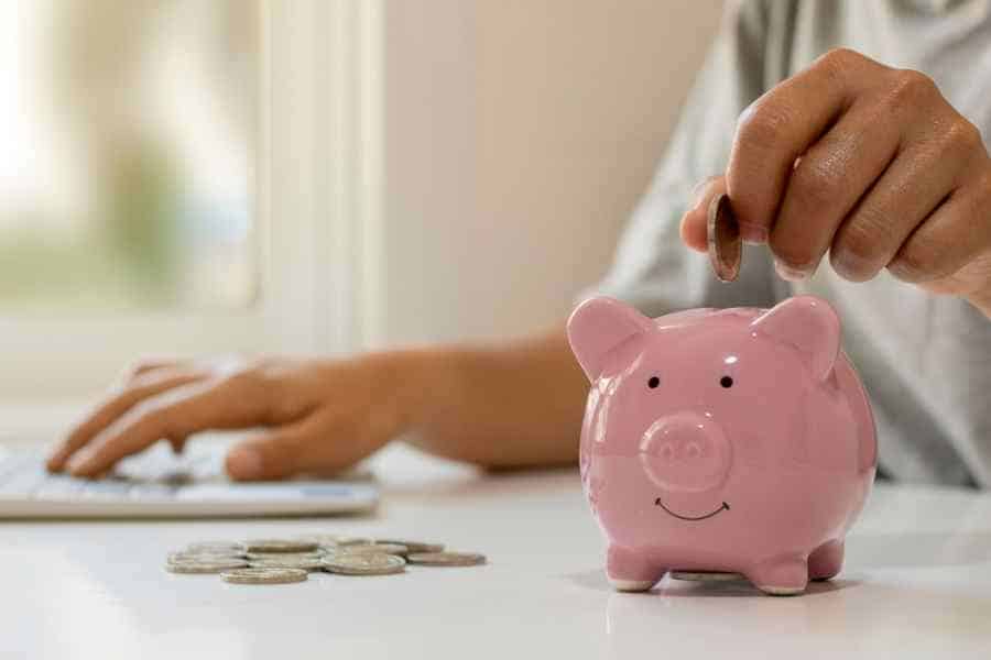 woman saving money in a pink piggy bank