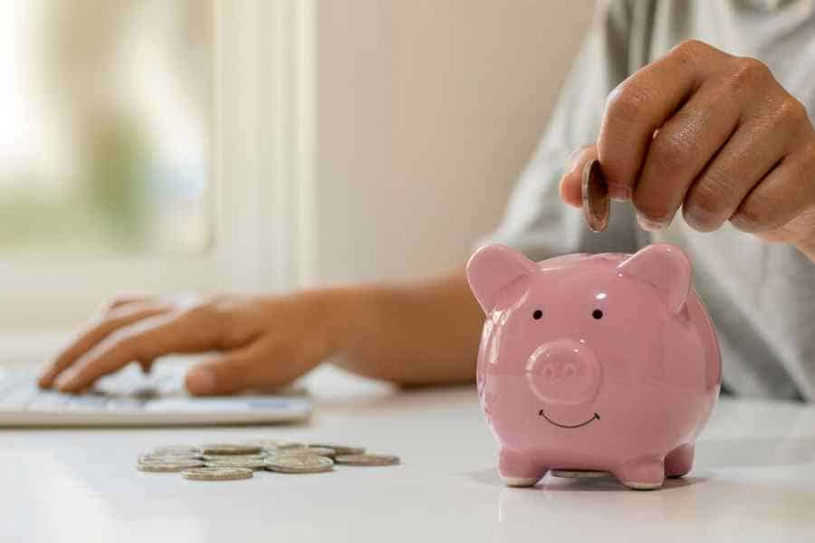 woman saving money in a pink piggy bank