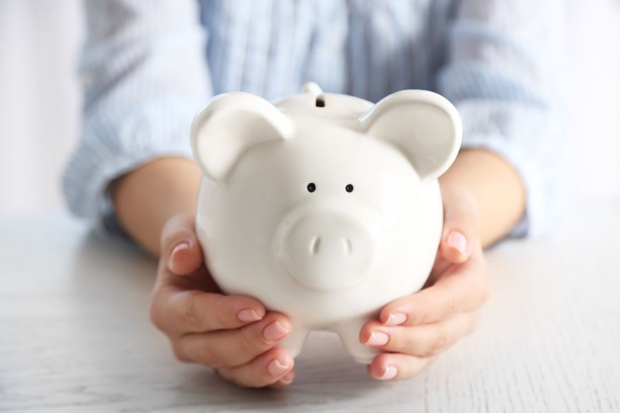 woman holding a white piggy bank