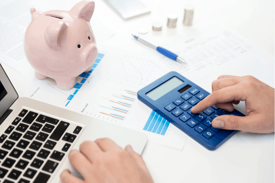 a person using a blue calculator and a laptop to make their budget