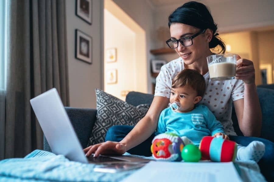 woman working online with her baby in her lap