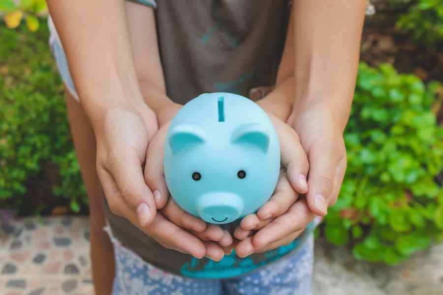 mother and child holding a piggy bank