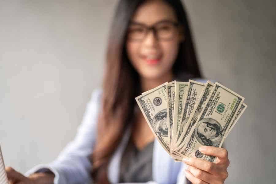 woman holding 10k in cash