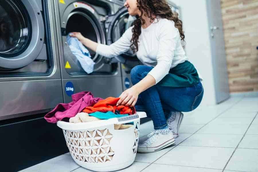 woman loading clothes into a washing machine