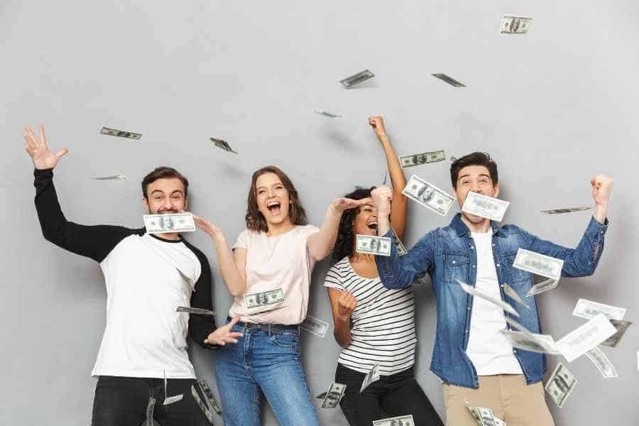 four people throwing cash in the air