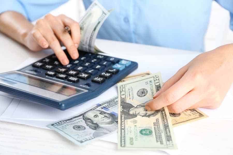 woman counting money using a calculator