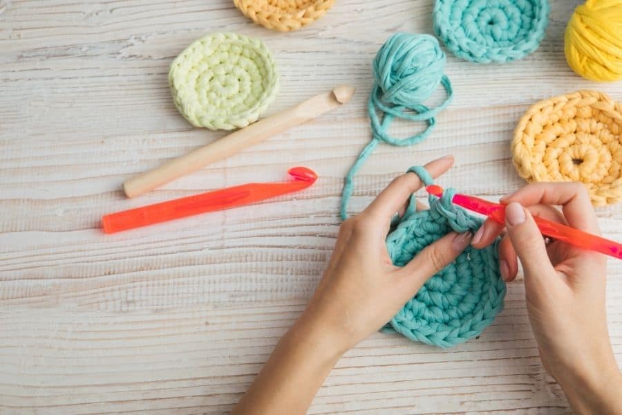 woman crocheting something with blue yarn