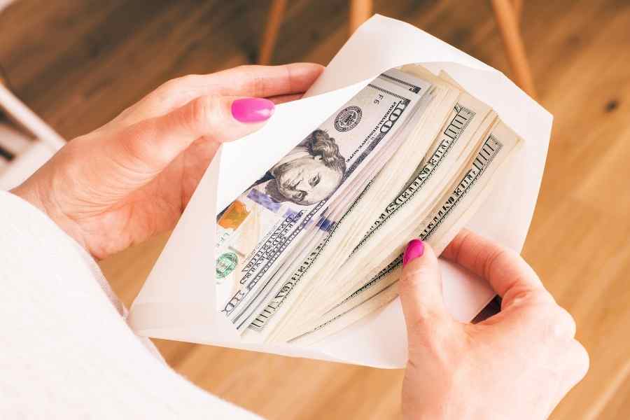 woman holding an envelope full of cash