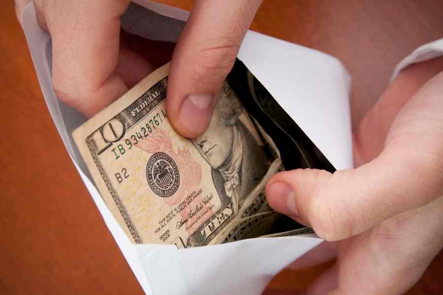 person holding an envelope full of cash