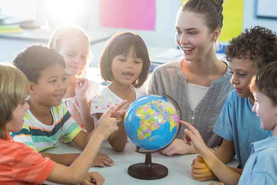 teacher showing kids a globe