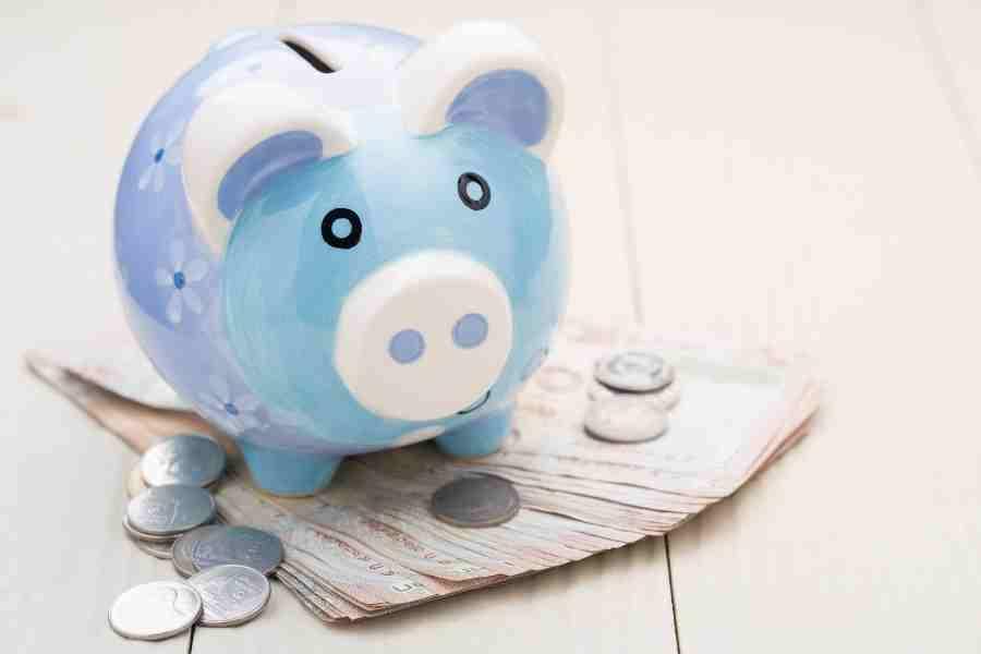 blue piggy bank with cash and coins