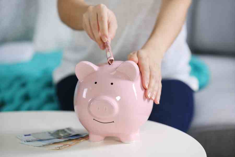 woman adding money to a piggy bank