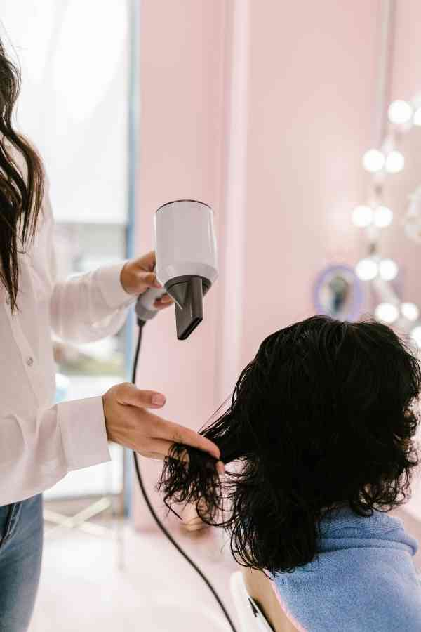 woman blowdrying hair in a salon