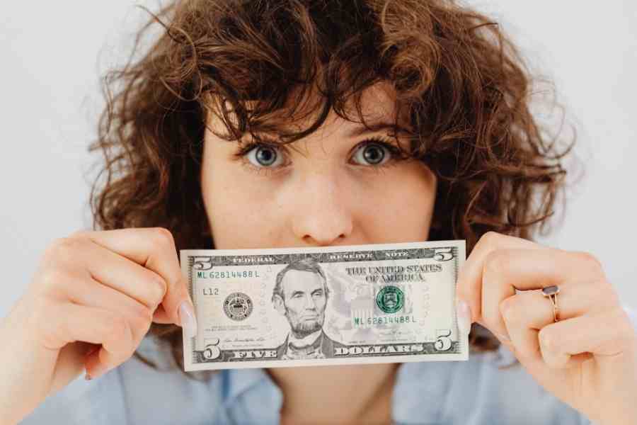 woman holding money over mouth