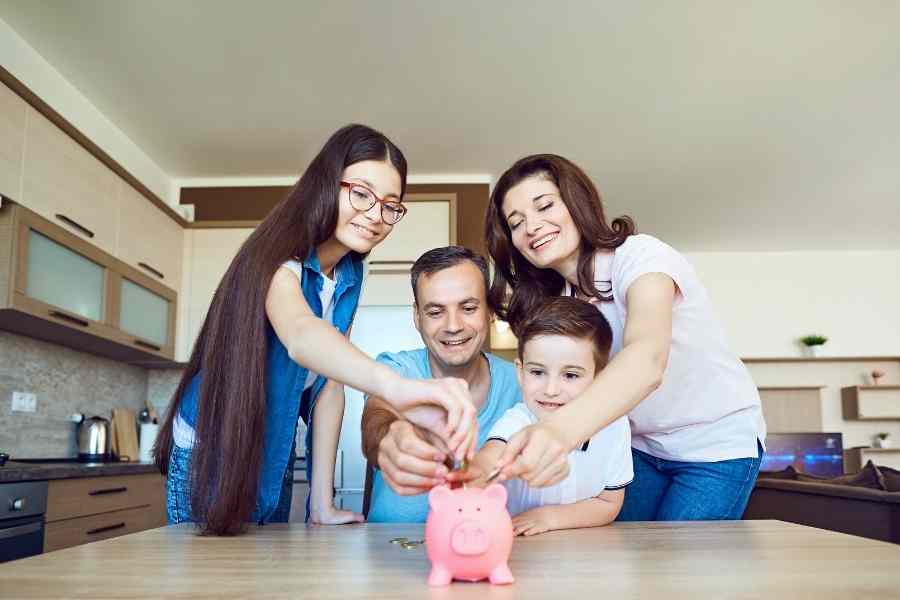 family adding money to a piggy bank - budgeting for teens