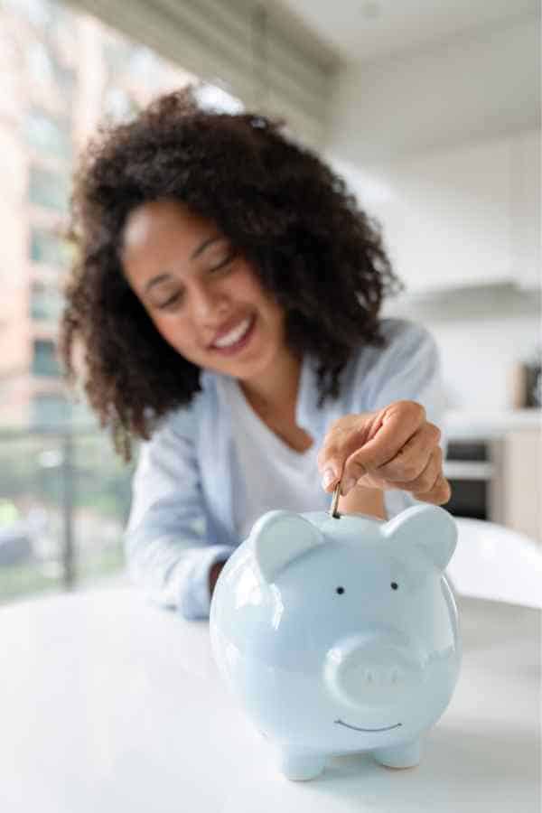 woman putting money in a piggy bank