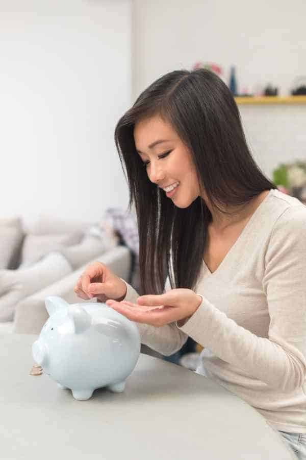 woman counting coins into a piggy bank